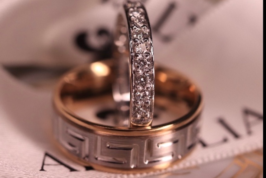 Diamond ring sitting upright on silver and gold broad ring.