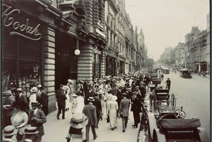 A black and white photo of a busy shopping street