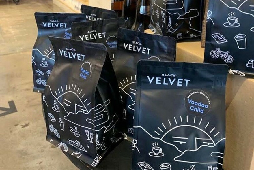 Vacuum sealed packs of Black Velvet coffee beans for purchase.