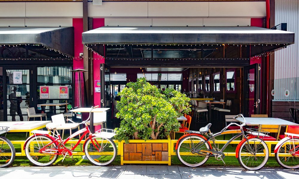 A restaurant with red bikes parked outside.