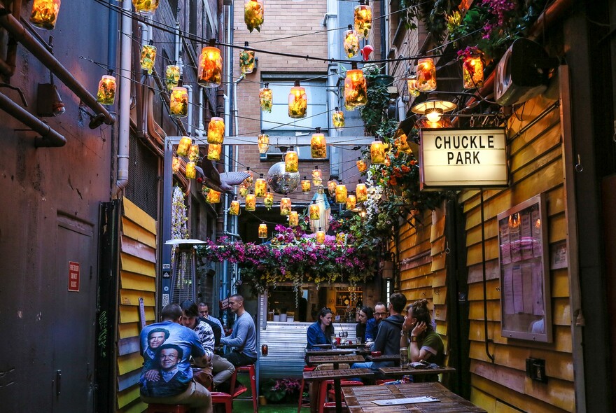 Small outdoor bar in a laneway with hanging lanterns.