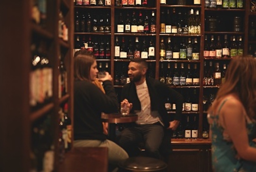 People drinking in a bottle store.