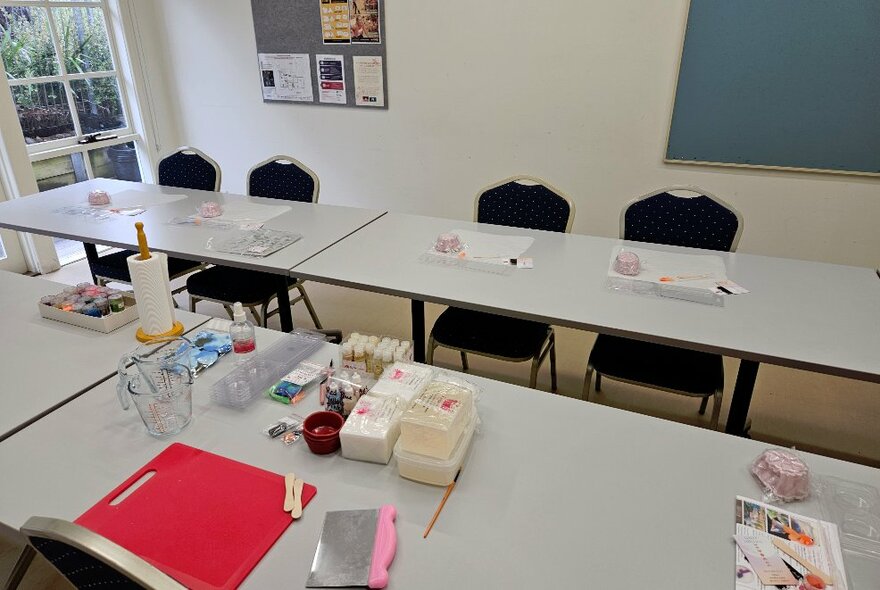 A workshop space with tables and chairs and equipment laid out for a soap making class.