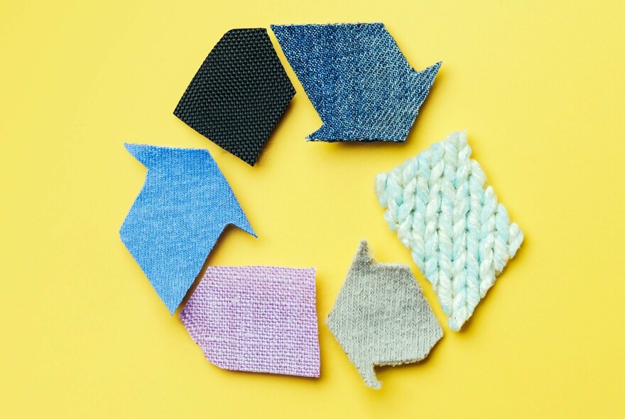Fabric swatches forming the shape of a recycle logo, on a yellow background.