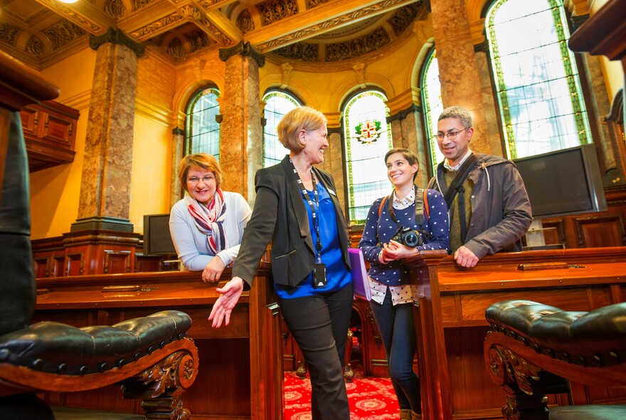 Small group of people being shown inside the historic council chamber room.