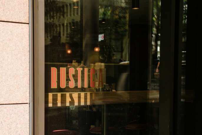 Exterior of Rustica cafe showing signage on the glass window.
