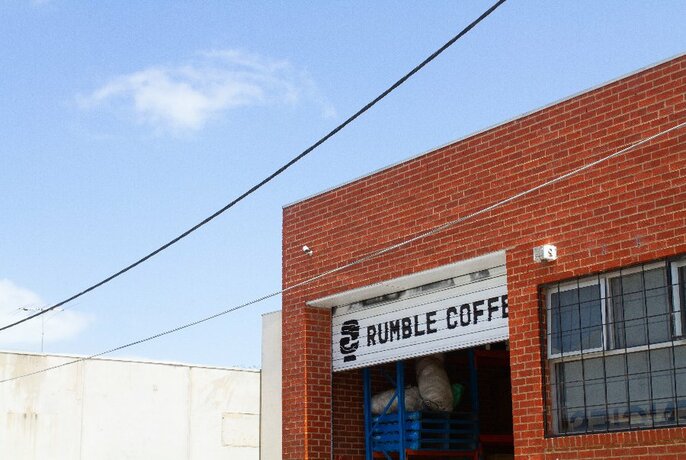 Looking up at the sky with the Rumble Coffee Roasters roller door up in the background.