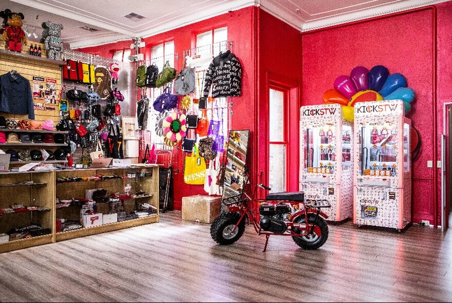 Shop interior with bright red walls, a counter and merchandise on display.