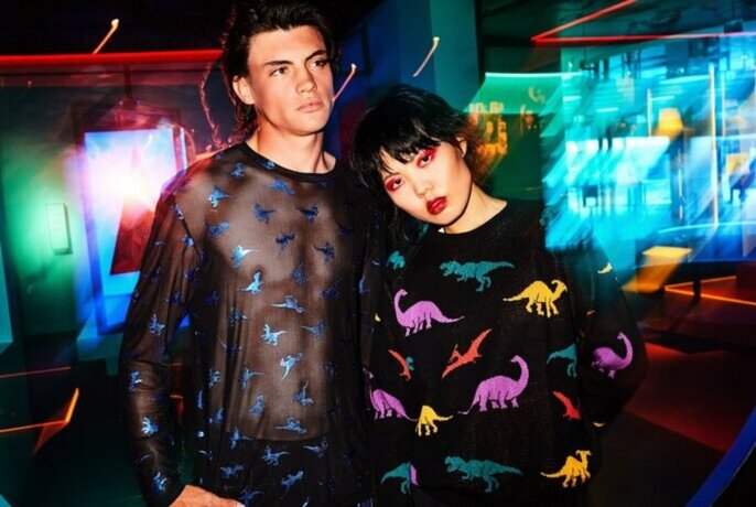 Models wearing with sheer black and a black jumper, both printed with dinosaurs. 