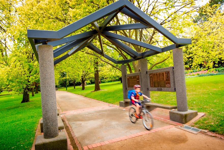 Child riding a bike in the park.