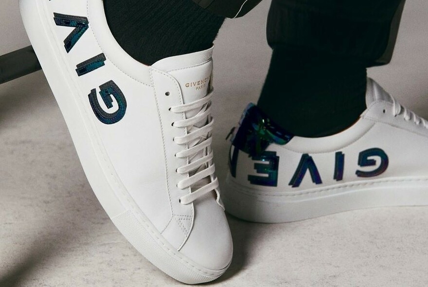 Detail of white Givenchy trainers with large brandname logo.