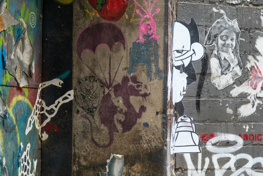 Close-up of parachuting rat graffiti by street artist Banksy in Melbourne laneway.
