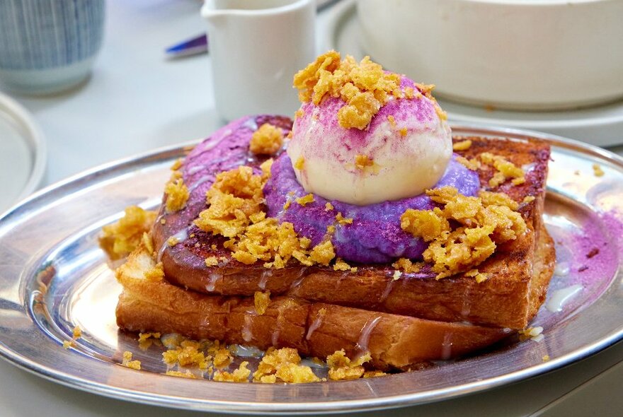 A plate of French toast with purple yam and ice cream on top