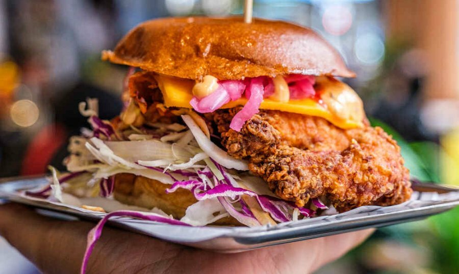 A fried chicken burger on a metal tray