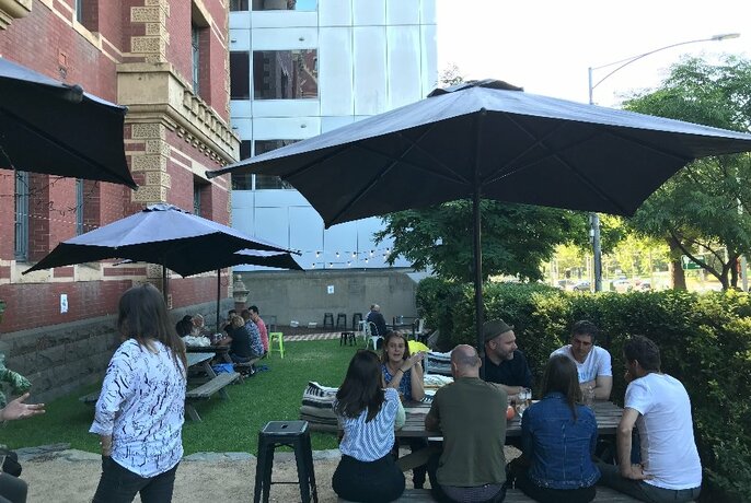People seated under a shade umbrella.