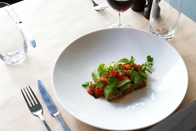 Italian entree garnished with watercress and tomato.