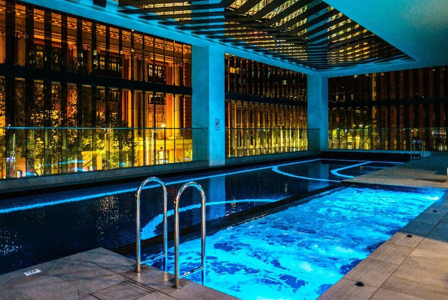 A hotel pool lit up in blue