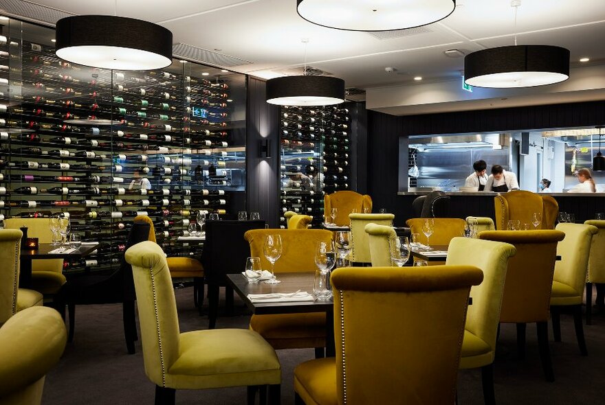 An elegant restaurant dining room with gold upholstered chairs.