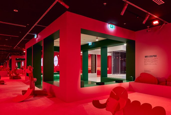 A red square room within a larger space. 