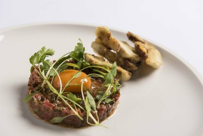 Steak tartare on a large white plate.