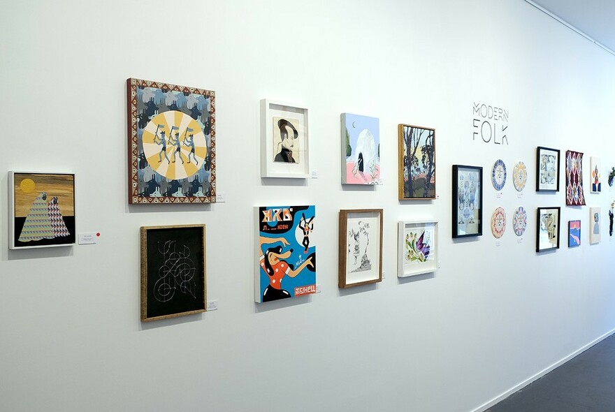 White wall at Outre Gallery displaying small framed artworks for sale.