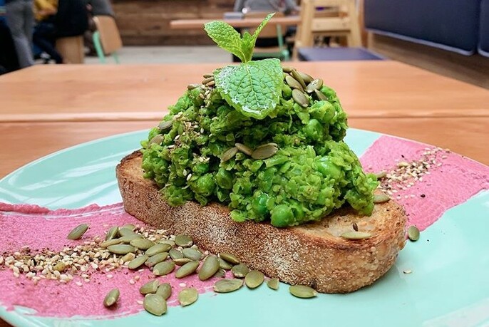 Mashed peas on brown bread with sprig of mint garnish.
