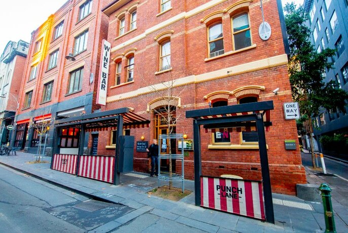 Melbourne laneway bar Punch Lane, with striped pavement seating outside heritage orange brick building.