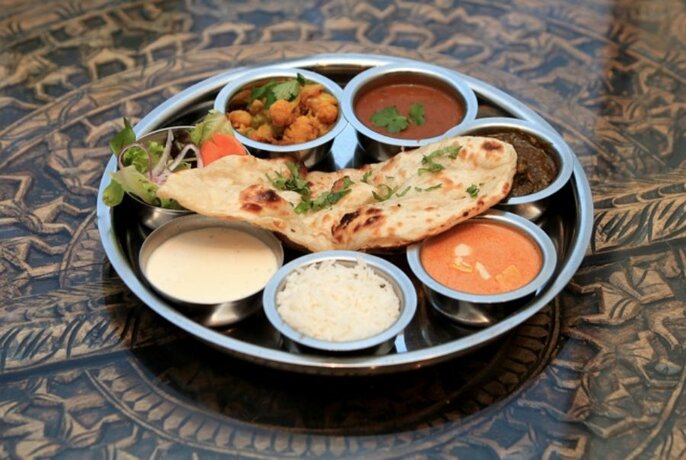 Indian thali meal, made up of a selection of various dishes, served on a platter. 