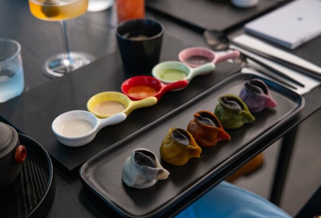 Different coloured dumplings on a black plate