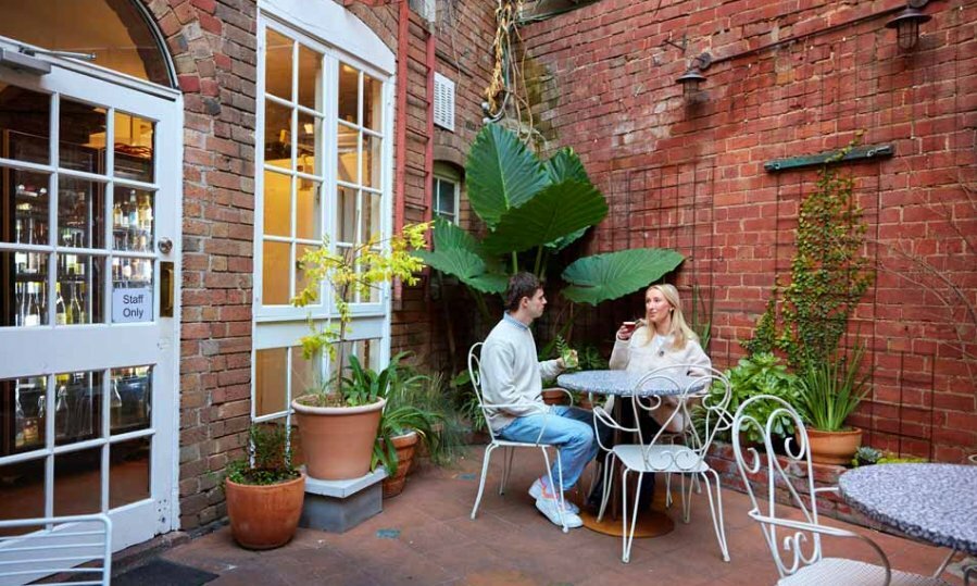 A couple having a drink in a bar's outdoor courtyard