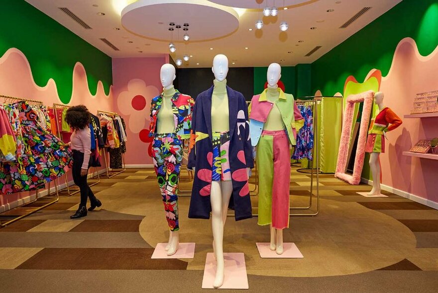A fashion boutique with three mannequins in colourful outfits.
