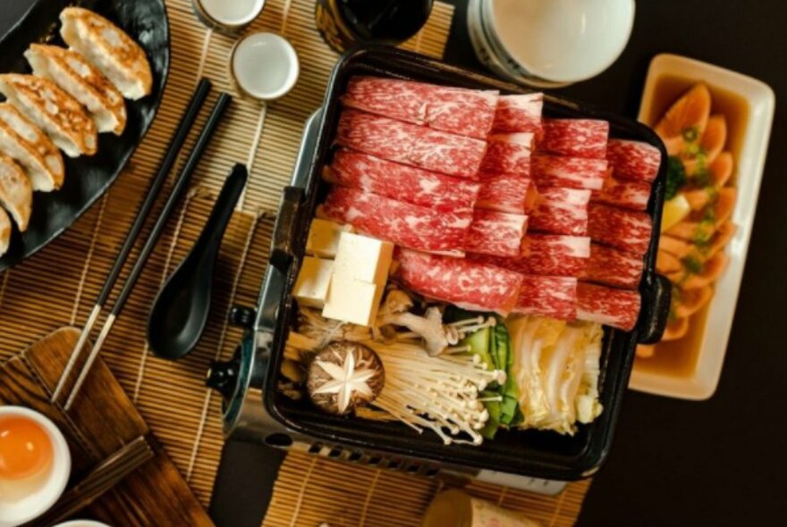 A platter of Japanese ingredients and dumplings.