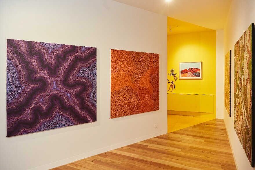 Inside an art gallery displaying large Indigenous paintings.