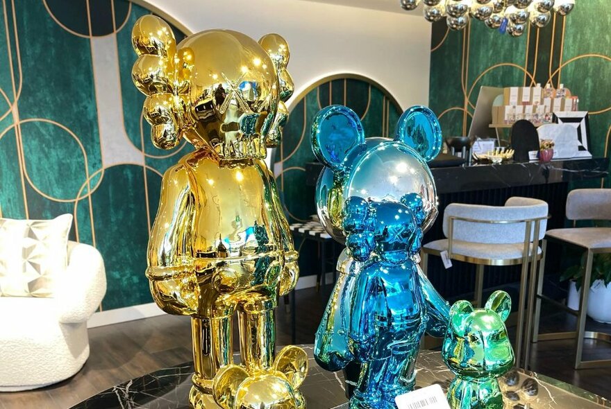 Gold and blue metallic sculptures on display in a shop selling furniture and homewares.