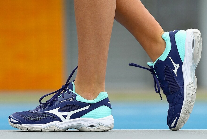 Close up of standing feet in a pair of running shoes.
