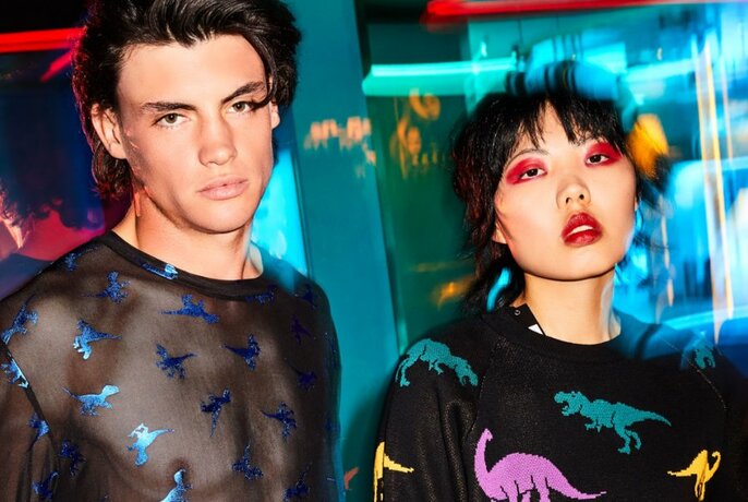 Two models wearing black tops with colourful dinosaurs 