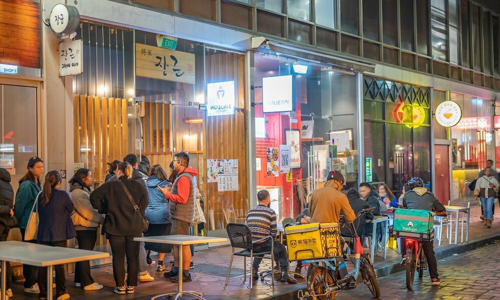 A busy laneway of restaurants at night.