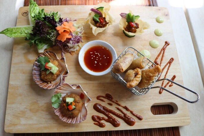 Looking down on a table with a mixture of Thai started dishes.