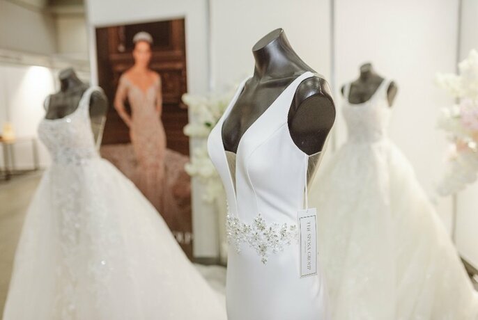 A room with bridal gowns on headless black mannequins. 