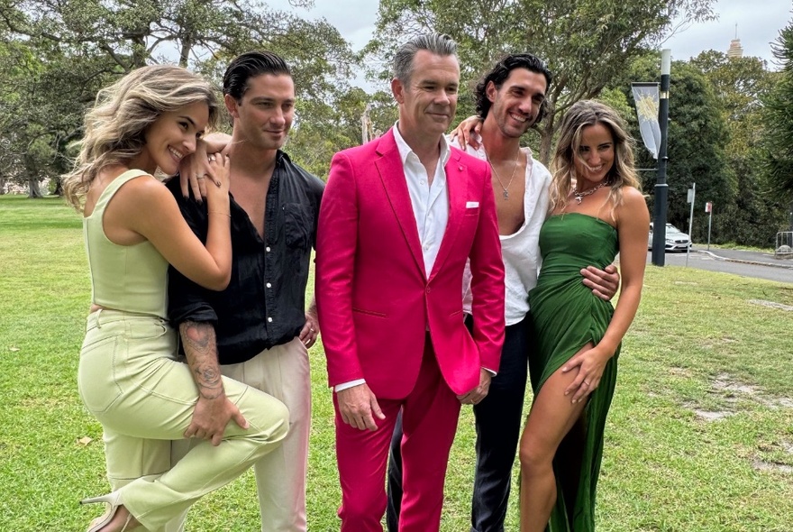 Four professional dancers posing in a park with Phil Burton from Human Nature, who is wearing a vibrant pink suit.