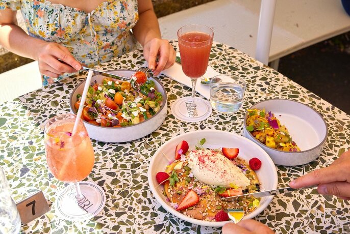 A terrazzo table with colourful brunch dishes and cocktails. 