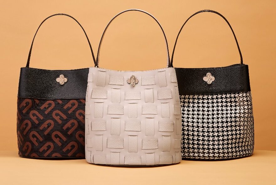 Three handbags of the same style featuring different colours and patterns. 