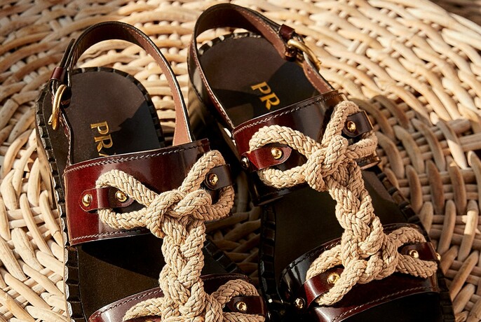 Detail of rope and leather sandals on a wicker background.