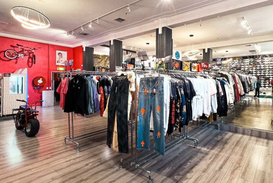 A fashion boutique with men's clothing, bikes on display and a wall of sneakers.