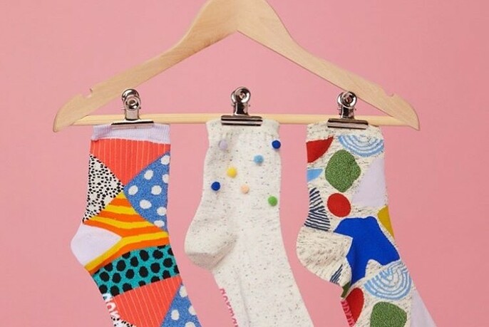 Three colourful socks on a hanger.