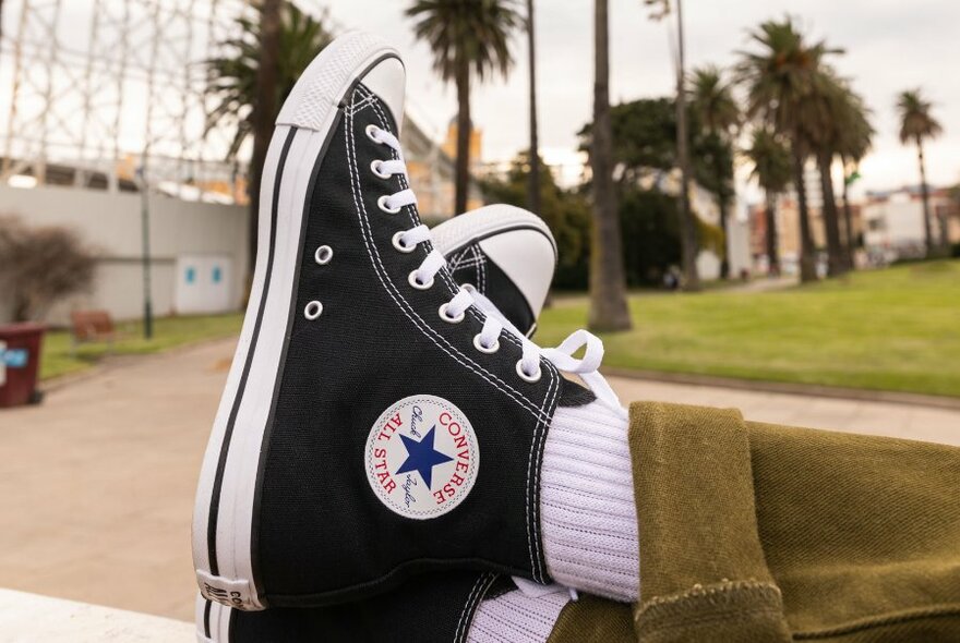 Feet in a pair of classic black converse sneakers.