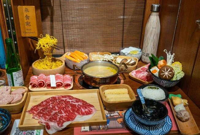 Plates of meat and vegetable on a wooden table.