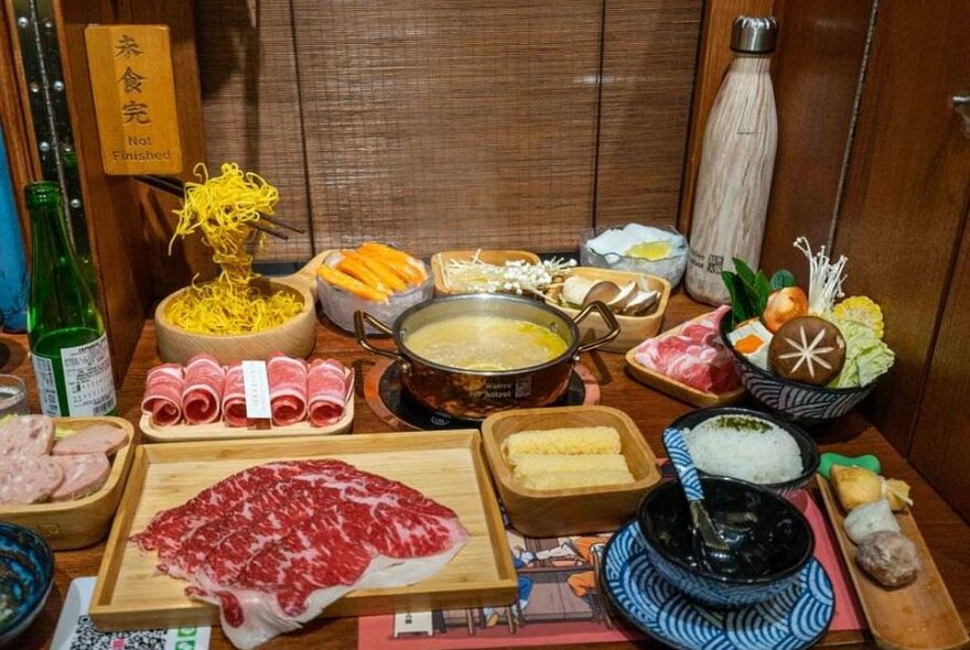 Plates of meat and vegetable on a wooden table.