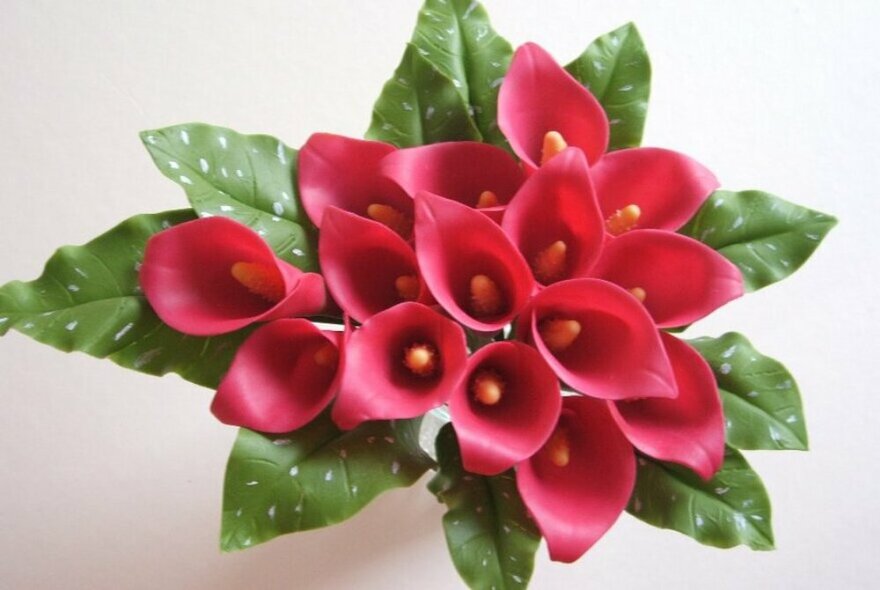 A bunch of red calla lily flowers, crafted from clay.