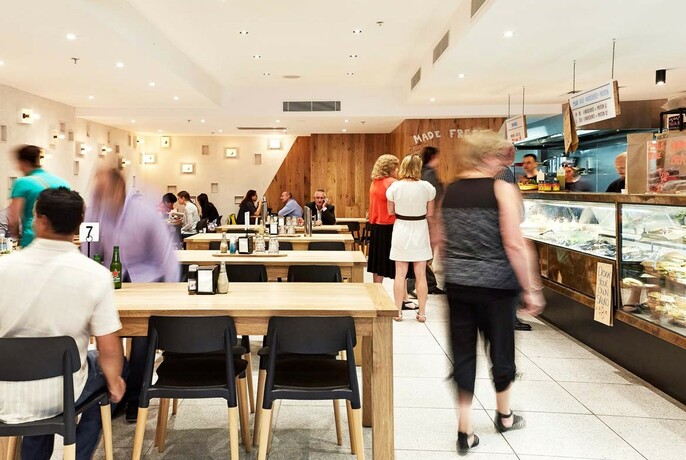 Interior of people moving and eating at 720 Bourke St.